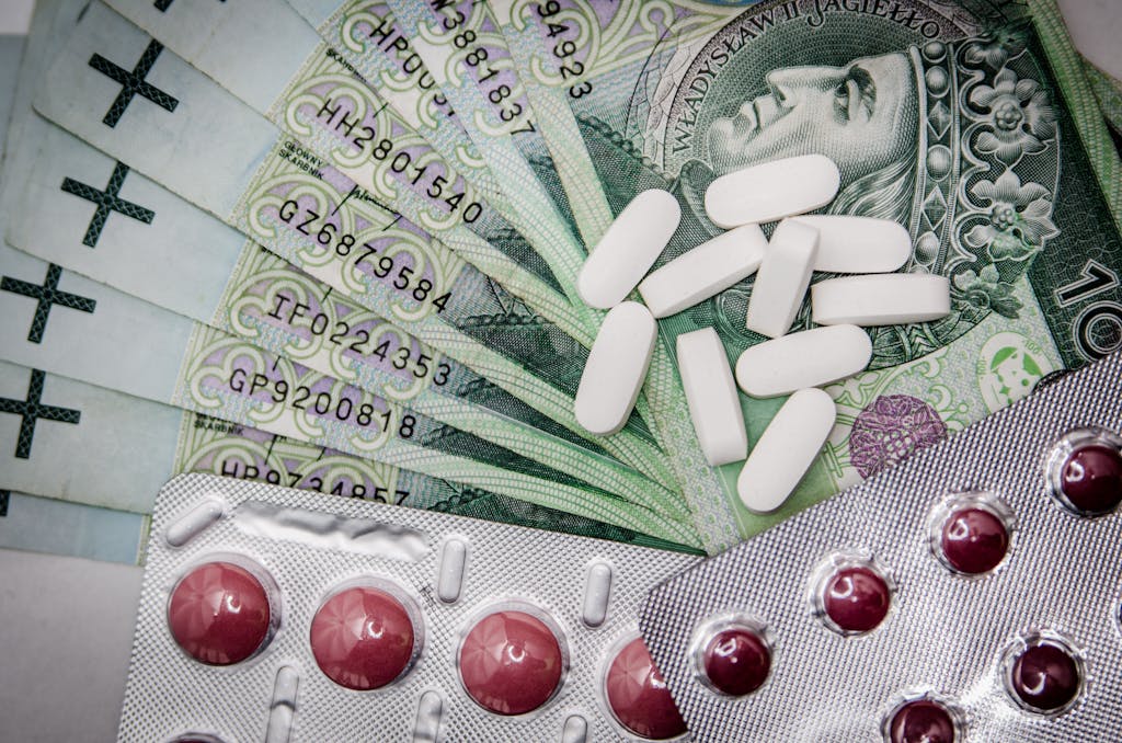 Polish 100 złoty notes with pills and blister packs, illustrating medical costs.