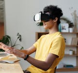 Teenager wearing a VR headset and interacting in a home setting, enjoying virtual reality experience.