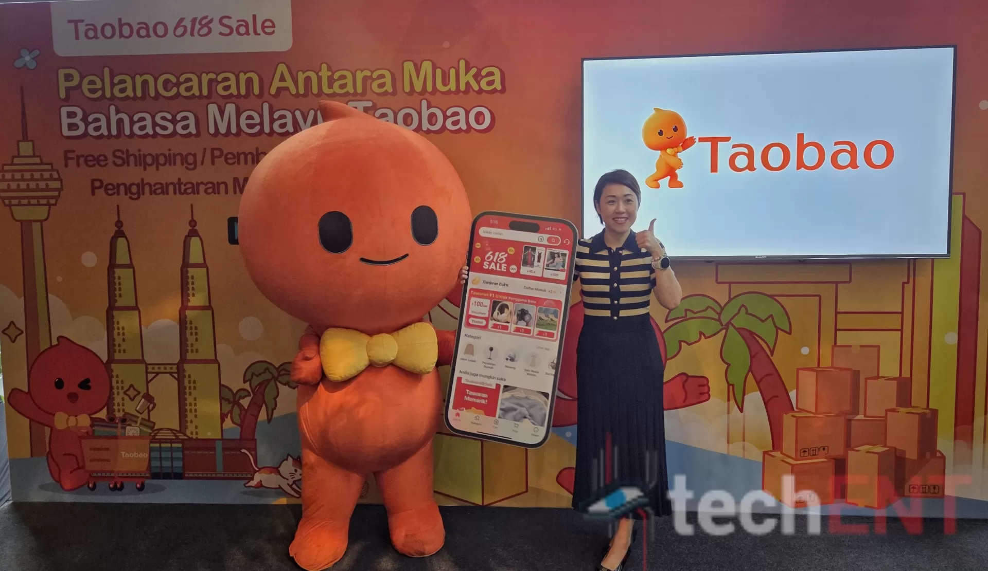 taobao BM with Jes Lew Jess Lew, Country Manager of Taobao Malaysia stands with the Taobao Mascot at the Launch of the Bahasa Malaysia Interface